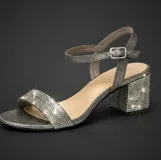 Sandalia de fiesta color plateado con acabado brillante, diseño de tira frontal y pulsera al tobillo con hebilla ajustable. Cuenta con taco cuadrado bajo cubierto de pedrería brillante.