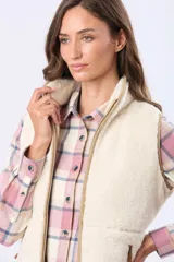 Chaleco de tejido sherpa color beige, con cuello alto y detalles en eco cuero. Diseño sin mangas que proporciona abrigo al torso manteniendo la libertad de movimiento.