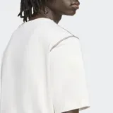 Remera color crema de corte clásico, con logo de Adidas Originals estampado en el pecho en color violeta.