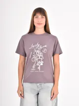 Remera color gris topo con estampa frontal en blanco que incluye gráficos de llaveros y la inscripción "Lucky Charm".