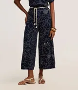 Pantalón recto de viscosa color azul marino con estampado lineal de follaje en blanco. Posee talle alto con trabillas y se ajusta con un cinturón de cuerda blanco. El pantalón es de corte cropped.