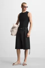 Chancla tipo pala monocolor negra, con suela de goma y tira ancha en el empeine con relieve acanalado.