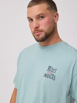 Remera negra de algodón con corte oversize y estampado frontal pequeño en blanco con el texto "Rusty Manira".