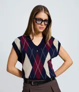 Chaleco de punto de cuello en V sin mangas, con estampado de rombos argyle en tonos azul marino, bordó y beige. Presenta bordes acanalados en el cuello y sisas.