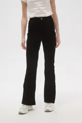 Pantalon de corte flare y tiro alto, confeccionado en tejido de algodón con textura aterciopelada, de color negro.