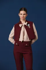 Chaleco negro de corte corto y estructurado, con cierre frontal y diseño minimalista.