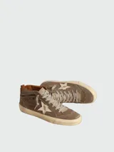 Zapatillas de caña media Golden Goose, color marrón con efecto desgastado. Presentan una estrella lateral de cuero en tono claro, cordones al tono y suela de goma con acabado envejecido.