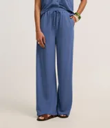 Pantalón recto color azul, confeccionado en tejido orly, con elástico y lazo ajustable en la cintura.