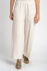 Pantalón de corte recto y holgado, confeccionado en tejido liviano color arena con textura jaspeada. Presenta cintura elástica con cordón interno, bolsillos frontales tipo parche y un calce fluido.