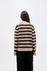 Saco de punto con diseño de rayas horizontales en tonos beige y marrón, cuello en V, cierre frontal con botones y bolsillos laterales. Presenta un corte holgado y mangas largas con puños acanalados.