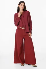 Camisa de manga larga color azul, con cuello mao y detalle de volados en la botonadura frontal. Presenta puños abotonados y un corte recto y fluido.