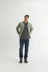 Sobrecamisa verde oliva de pana con cuello solapa, calce holgado, bolsillos con tapa en el pecho y botones personalizados.