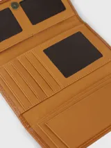 Billetera de cuero combinada en tonos camel y marrón, de formato rectangular con solapa. Cuenta con un parche central decorativo con logo grabado y detalles de costura perimetral.