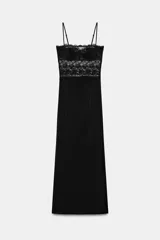 Vestido midi negro con escote recto y tirantes finos ajustables. Presenta un cuerpo superior con detalle de encaje floral y copas estructuradas, mientras que la falda es de corte recto y tejido liso.