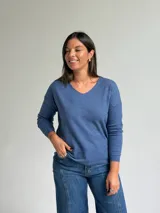 Sweater de punto color azul, con escote en V, manga larga y diseño de calce holgado.