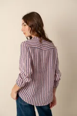 Camisa de lino a rayas verticales azules y blancas, con cuello mao, manga larga con puño elástico y cierre frontal con botones.