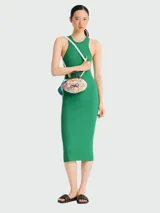 Bolso de mano tipo cesta de la línea Le Pliage Mesh de Longchamp, en tamaño XS. Presenta una estructura de red tejida en color marfil con detalles de lazos bordados en tonos pastel y asas cortas de cuero marrón. Incluye una correa larga ajustable para llevar al hombro o cruzado.