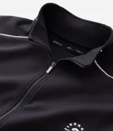 Buzo deportivo de corte boxy, color negro, con cuello alto, cierre frontal completo y mangas largas. Presenta detalles de líneas blancas a lo largo de las mangas y lettering estampado en el pecho.