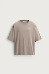 Camiseta boxy fit color gris topo, de cuello redondo y manga corta, con pequeño estampado frontal a contraste.