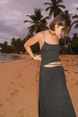 Falda larga tejida color marrón con brillo metálico, corte al cuerpo, abertura alta en la pierna y recortes laterales con cordones ajustables.