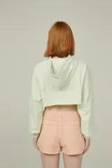 Buzo color durazno, corto, con capucha y mangas largas.