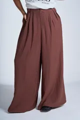 Pantalón sastrero marrón de corte palazzo, con botón, pasacinto y pretina trasera con elástico.