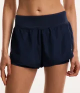 Bermuda deportiva tipo runner de microfibra color azul marino, con cintura elástica, bolsillo con cierre y diseño holgado con bajo redondeado.