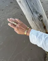 Pulsera tipo esclava abierta con diseño rústico y acabado irregular, fabricada en bronce y alpaca.