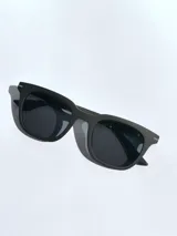 Lentes de sol con armazón de color gris mate y detalles en azul en las patillas. Cuentan con cristales oscuros polarizados y protección UV 400.