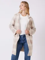 Chaqueta de tejido suave con estampado a cuadros en tonos beige y blanco, cuello con solapa y cierre de botón frontal. Incluye bolsillos delanteros.