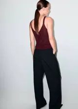 Top de punto fino con lurex, color bordó, de corte recto, escote en V y tirantes finos.