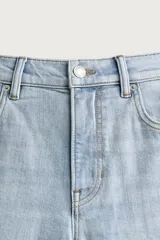 Jeans slim fit de tiro medio, color celeste claro con efecto lavado. Confeccionados en tejido elástico, cuentan con diseño de cinco bolsillos y cierre frontal con cremallera y botón metálico.