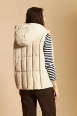 Chaleco acolchado de nylon color negro, con diseño capitoneado, capucha integrada y cierre frontal con tirador metálico.