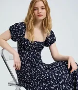 Vestido midi de viscosa con estampado floral liberty, escote recto, mangas cortas abullonadas y falda fluida con caída leve.