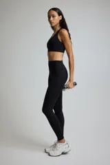 Top deportivo negro con espalda deportiva y soporte medio.