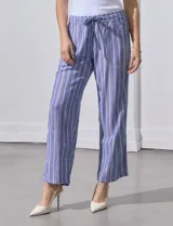 Pantalón de lino estampado a rayas verticales azules y blancas, marca DASH. Tiene pretina ancha elastizada con lazo ajustable.