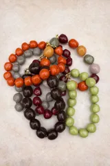 Collar de cuentas de resina de formas irregulares y acabado brillante, disponible en diversas combinaciones de colores, con cierre metálico dorado.