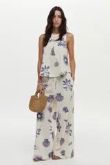 Musculosa de lino y viscosa, color crudo con estampado azul de barcos, libélulas, higos y hojas. Presenta escote redondo.