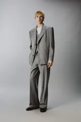 Blazer de corte regular confeccionada en tejido con lana, color gris. Presenta cuello con solapas de muesca, manga larga, bolsillos de vivo en el pecho y bolsillos de solapa en la cadera. Cuenta con cierre frontal de botones y aberturas en la espalda.