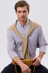 Camisa de manga larga con diseño a cuadros en tonos azul, blanco y rojo, cuello camisero abotonado, bolsillo en el pecho con logo bordado y cierre frontal con botones.