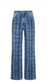 Pantalón de jean corte wide leg con tiro alto, confeccionado en denim azul. Presenta un diseño bordado vertical con líneas oscuras y detalles en hilo claro que recorren el frente de las piernas.