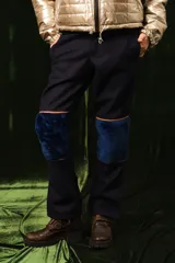 Pantalón de lana azul marino, de corte recto, con rodilleras de corderito en el mismo tono y detalles de ribetes tostados.