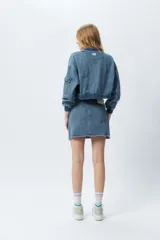 Minifalda de jean negra con corte asimétrico en el frente y deflecado tanto en la cintura como en el ruedo.