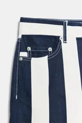 Jeans de tiro medio de corte slim, con diseño de rayas verticales a contraste en color azul marino y blanco. Cuenta con cinco bolsillos, trabillas para cinturón y cierre frontal con cremallera y botón metálico.