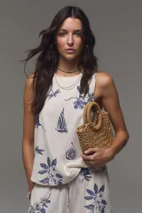 Musculosa de lino y viscosa, color crudo con estampado azul de barcos, libélulas, higos y hojas. Presenta escote redondo.