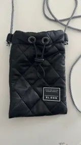 Porta celular negro acolchado con cordón largo a rayas blancas y negras.