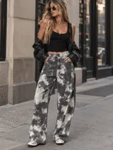 Pantalón jean ancho estilo baggy, de tiro semi alto, con estampa estilo tie-dye en tonos gris y blanco.