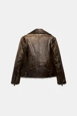 Chaqueta tipo biker de cuero con efecto desgastado, cuello de solapa, cierre frontal con cremallera metálica, bolsillos delanteros con cremallera y bolsillo pequeño con solapa, mangas largas con cremalleras en los puños y bajo con trabillas.