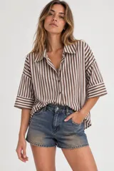 Camisa oversize a rayas blancas y marrones, de manga corta ancha y cierre frontal con botones.