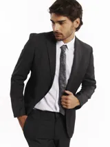 Traje de corte slim compuesto por saco con solapas, bolsillos laterales y forro interior, y pantalón a juego con bolsillos frontales y traseros.